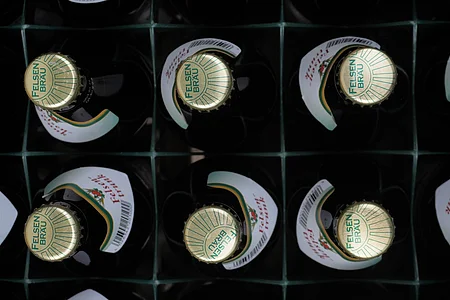 Kiste mit zwölf Felsenbräu-Bierflaschen, Draufsicht auf die Kronkorken.